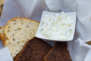 Curd snack with bread in a wicker basket.