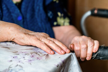 Hands of an elderly woman rests on on a walker. medical and healthcare concept.