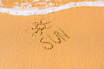 sun drawn on the sea sand. vacation concept