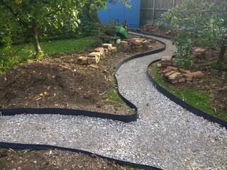 Landscape of garden design project building constructing a winding path with antique recycled house...