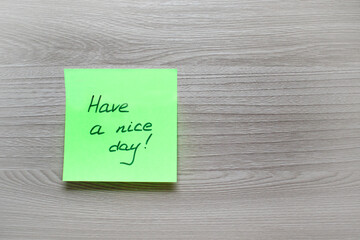 motivational cards. A Self adhesive sticker with the inscription have a nice day on a wooden gray background