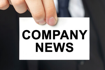 Businessman shows a card with the text - COMPANY NEWS