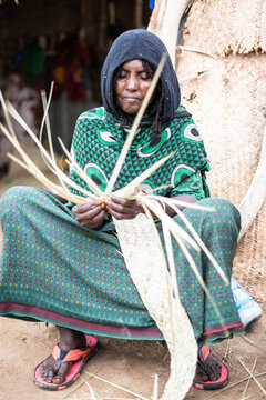 Elderly woman working with straw in Melabday village, Asso Bhole, Dallol, Danakil Depression, Afar Region, Ethiopia