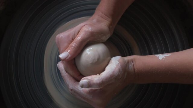 Young Artist Girl Hands Potter Making Handmade Ceramic Pot on the Twisted Pottery Wheel. Top view. Handmade, craft concept. White clay
