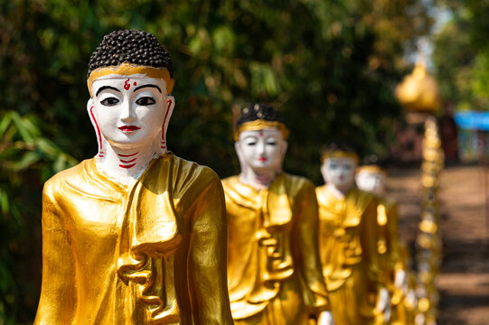 Long line of golden Buddhas lining up to Shwemawdaw Paya, Kyaing Ywar near Ye, Mon state