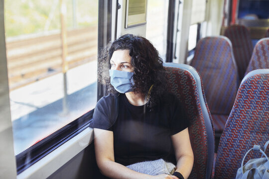 Young woman in a medical mask sitting in a train.
