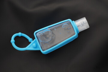 Blue bottle of hand sanitizer alcohol gel on black background. Pocketable small size.