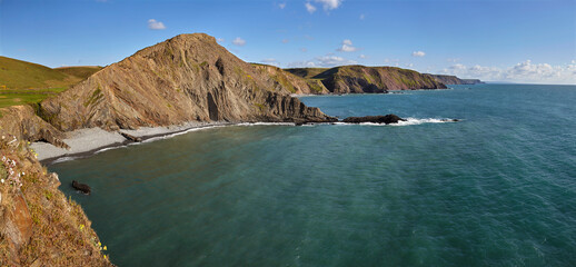 Rugged cliffs along southwest England's Atlantic coast, seen in calm summer weather, near Hartland Quay, in Devon, England, United Kingdom
