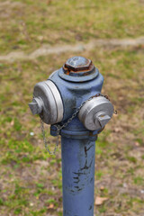 old rusty hydrant stands on a background of grass fire prevention