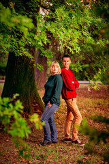 Naklejka na ściany i meble Beautiful woman,blonde,middle-aged,with a big son walking in the Park,a beautiful autumn day