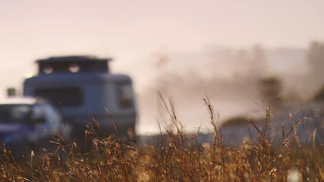 Coastal landscape with caravan trailer wild camping on beach. Capi Corb, Mediterranean coast of Spain. Holidays, traveling with motorhome. Focus on grass