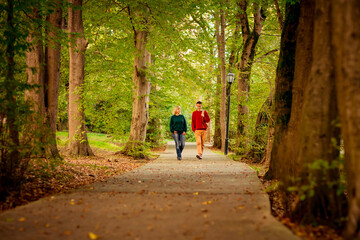 Obraz premium Beautiful woman,blonde,middle-aged,with a big son walking in the Park,a beautiful autumn day