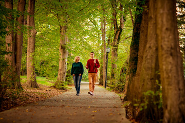 Beautiful woman,blonde,middle-aged,with a big son walking in the Park,a beautiful autumn day