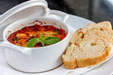 vegetable casserole with tomato sauce is in a white saucepan