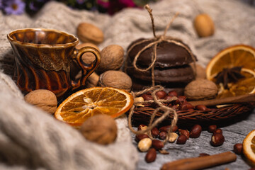 set for cozy autumn. cozy autumn. cup of tea, chocolate cookies, candle, cinnamon, anise, nuts on white knitted sweater. Hygge lifestyle