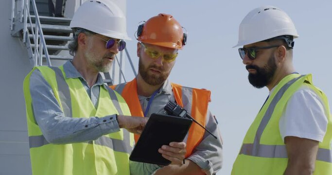 Male engineers talking on wind farm