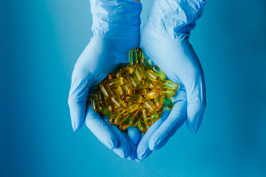 Insulated Hand with pills. on a blue background. The concept of protecting your life from viruses and living. Copy space for text. Inscription from medicines. Pandemic Covid-19 Coronavirus.