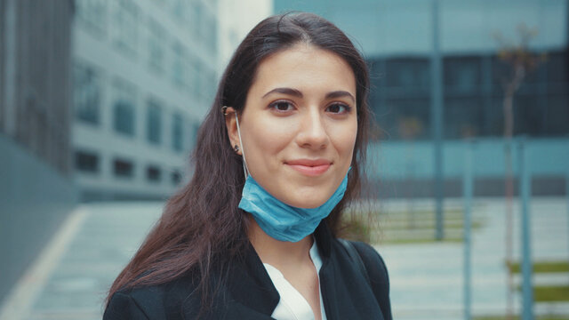 Happy young caucasian girl office woman removing facial mask virus protection enjoying healthy breathing fresh air smiling on camera. Pandemic is over. Female portraits.