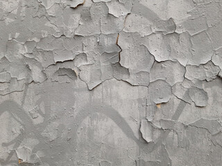 Old gray wall with cracks in plaster and paint. Destruction of graffiti