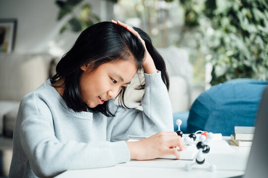 Elementary science student using plastic atom model educational toy