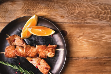 Grilled salmon on a skewer in a dark plate is on the table. Healthy food concept