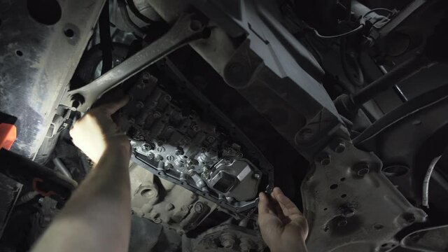 CVT gearbox close up, worker hands changing oil and making maintenance in new modern variator automatic transmission on SUV in Car Service.