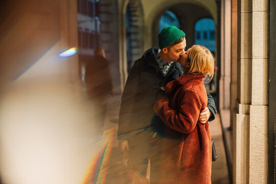 Couple kissing outdoor in the city during a cold winter day