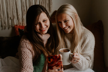 Two best friends decorating for christmas and hanging out at home