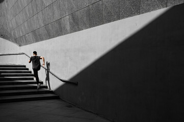 Male runner runs in a concrete architecture