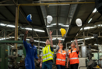 Group of Successful construction multiethnic engineer and African American technician worker throwing a hard hat in the Industry manufacturing factory. Workplace gender equality concept