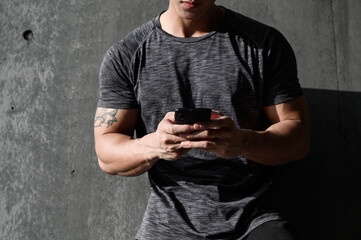 Sportsman taking a rest and using his smartphone