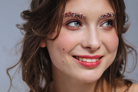 Smiling woman with festive make up looking away