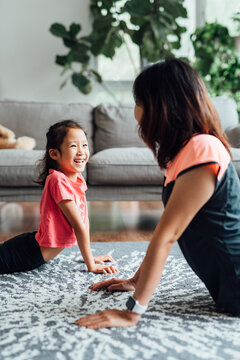 Chinese mother and daughter doing yoga at home