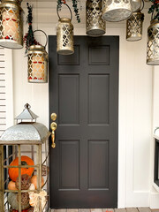 Front porch decorated for autumn. Vintage door with lamps