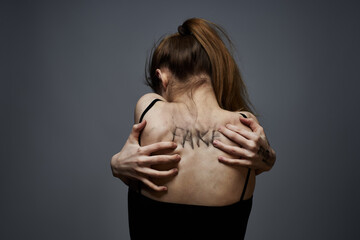 woman with offensive inscriptions on her body touching herself with hands stress frustration hate