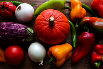 Colorful vegetables background. Harvest, autumn mood. Fresh raw pumpkin, bell peppers, chili peppers, tomatoes, onions and eggplant. Concept of healthy food, detox. Organic food. Selective focus