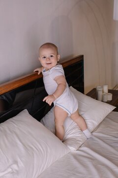 Cheerful 11 month old boy in parents bed