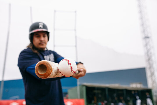 Batter hitting baseball ball with bat