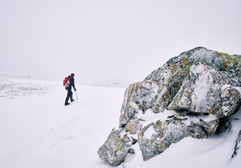 Winter mountaineer using Ice Axe and crampons below Great End. Esk Hause, Cumbria, UK.