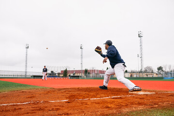 Cheerful ethnic baseman catching ball