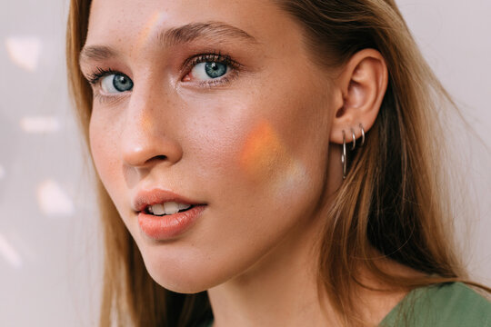 Woman with small rainbow on her cheek