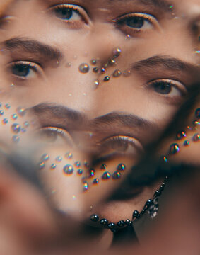 Unrecognizable model with shiny crystals around eyes