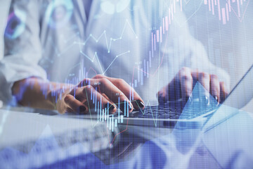 Double exposure of woman hands typing on computer and forex chart hologram drawing. Stock market invest concept.