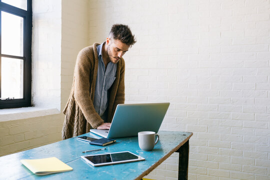 Man standing and working at laptop