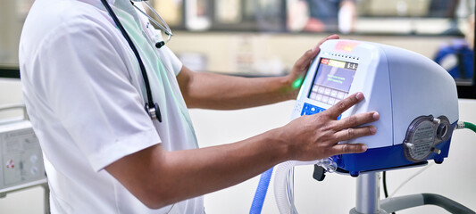 Doctor setting up a medical ventilator for lung and breathing support