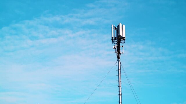 Time lapse of white clouds moving over telecommunication tower with 4G or 5G cellular network antenna. New mobile broadcasting technology generation.