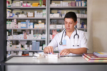 Doctor in a pharmacy sorting out medicine