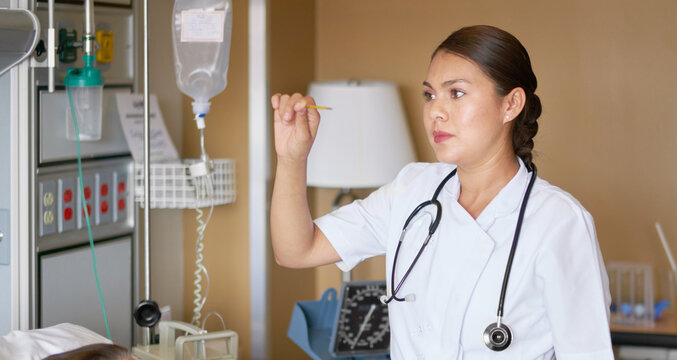 Medical practitioner checking the IV drip of a patient