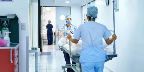 Hospital workers moving a bed to another room