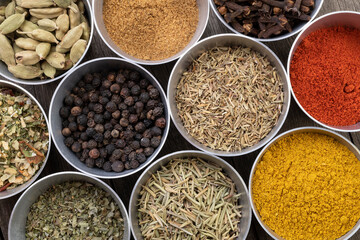 Seasonings on metallic bowls over wooden table